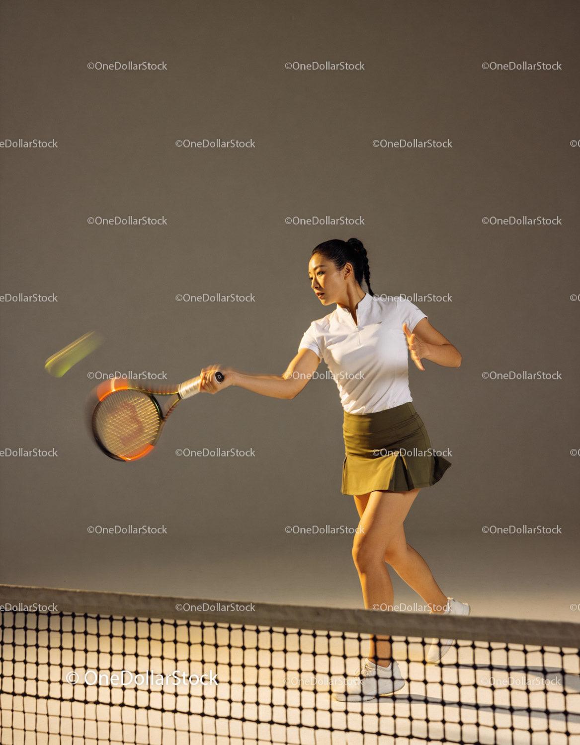 Focused female tennis player hitting a forehand shot