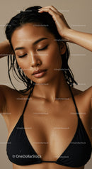 Beautiful woman with water droplets on skin in a black swimsuit