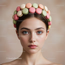 Young woman with colorful macarons headband in soft light