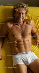 Smiling muscular man relaxing on bright yellow bed