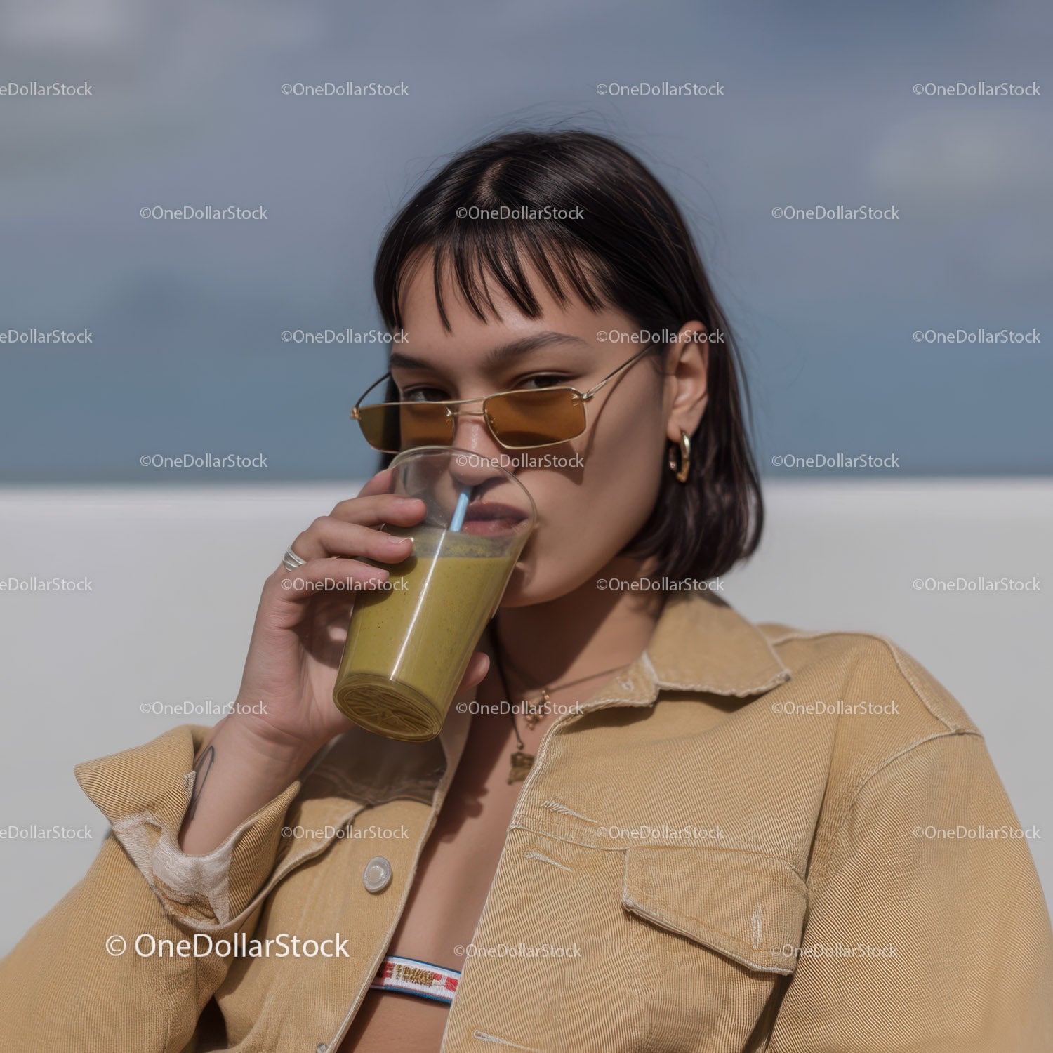 Young Woman Drinking Yellow Smoothie in Casual Summer Outfit