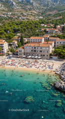 Scenic Beach with Mountain Backdrop and Vibrant Sunbathers