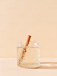 Refreshing sparkling drink with cinnamon stick on neutral background
