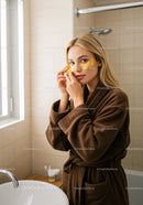 Young Woman Applying Facial Mask in Modern Bathroom