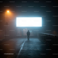 Solitary figure walking under bright billboard at night