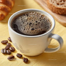 Delicious Coffee in a White Cup with Roasted Beans on Wooden Plate