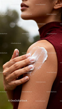 Woman Applying Cream on Shoulder Outdoors