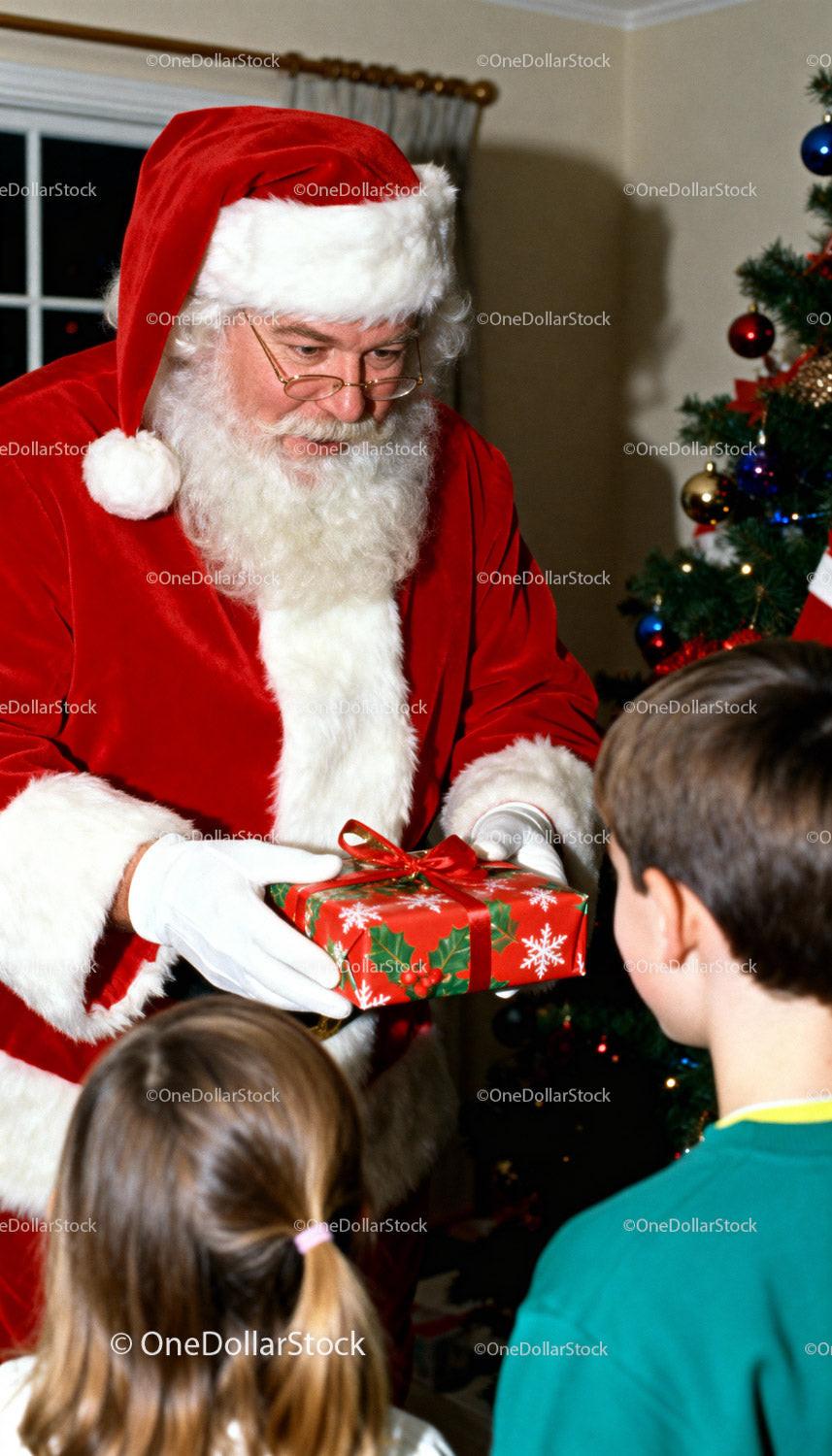 Santa Claus giving Christmas gift to excited children