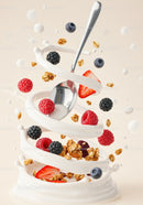 Fresh berries and granola swirling with creamy yogurt and spoon
