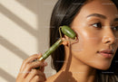 Young Woman Using Jade Roller for Facial Skincare and Relaxation