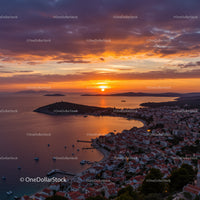 Vibrant Sunset Over A Small Coastal Town With Boats and Red Roofs