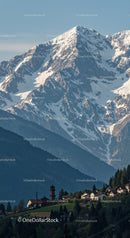 Majestic Snow-Capped Mountain with Mountain Village and Forested Hills