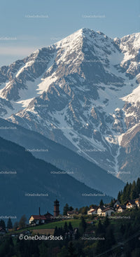 Majestic Snow-Capped Mountain with Mountain Village and Forested Hills