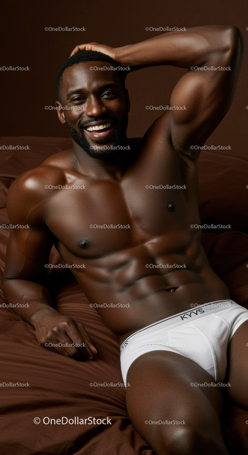 Smiling muscular man relaxing on brown bed linen