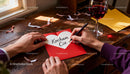 Writing a Heartfelt Love Note with Wine on Wooden Desk