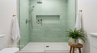 Modern walk in shower with green tiles and plant