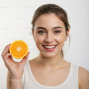 Happy Young Woman Holding Orange Slice for Fresh Summer Vibes