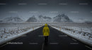 Lonely Traveler in Yellow Jacket on Snow-Covered Road
