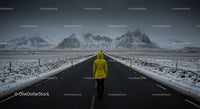 Lonely Traveler in Yellow Jacket on Snow-Covered Road