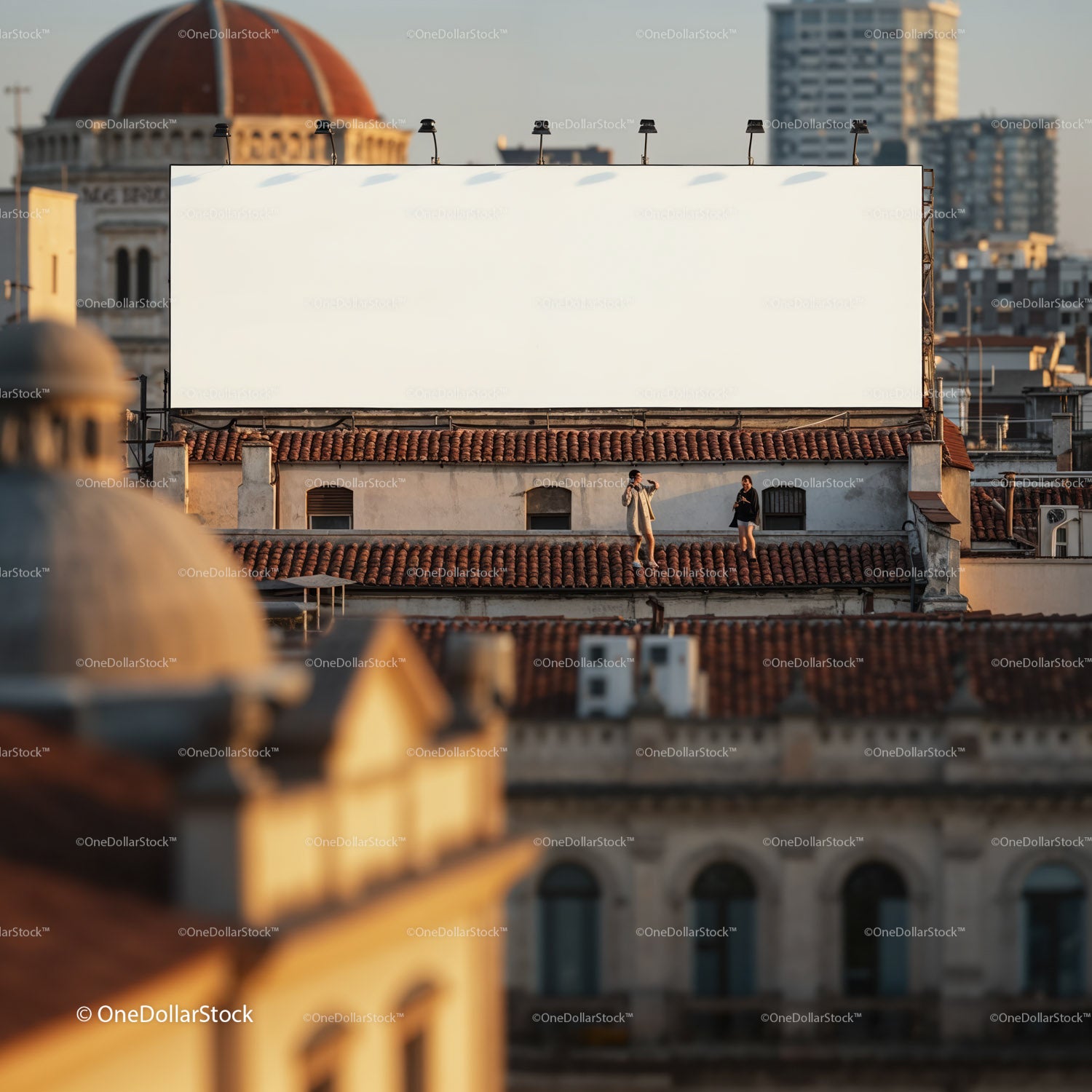 Para cieszy się widokiem na miejski dach pod dużym, pustym billboardem