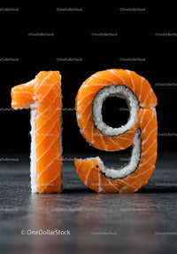 Sushi Rolls Forming Number Nineteen on Dark Surface