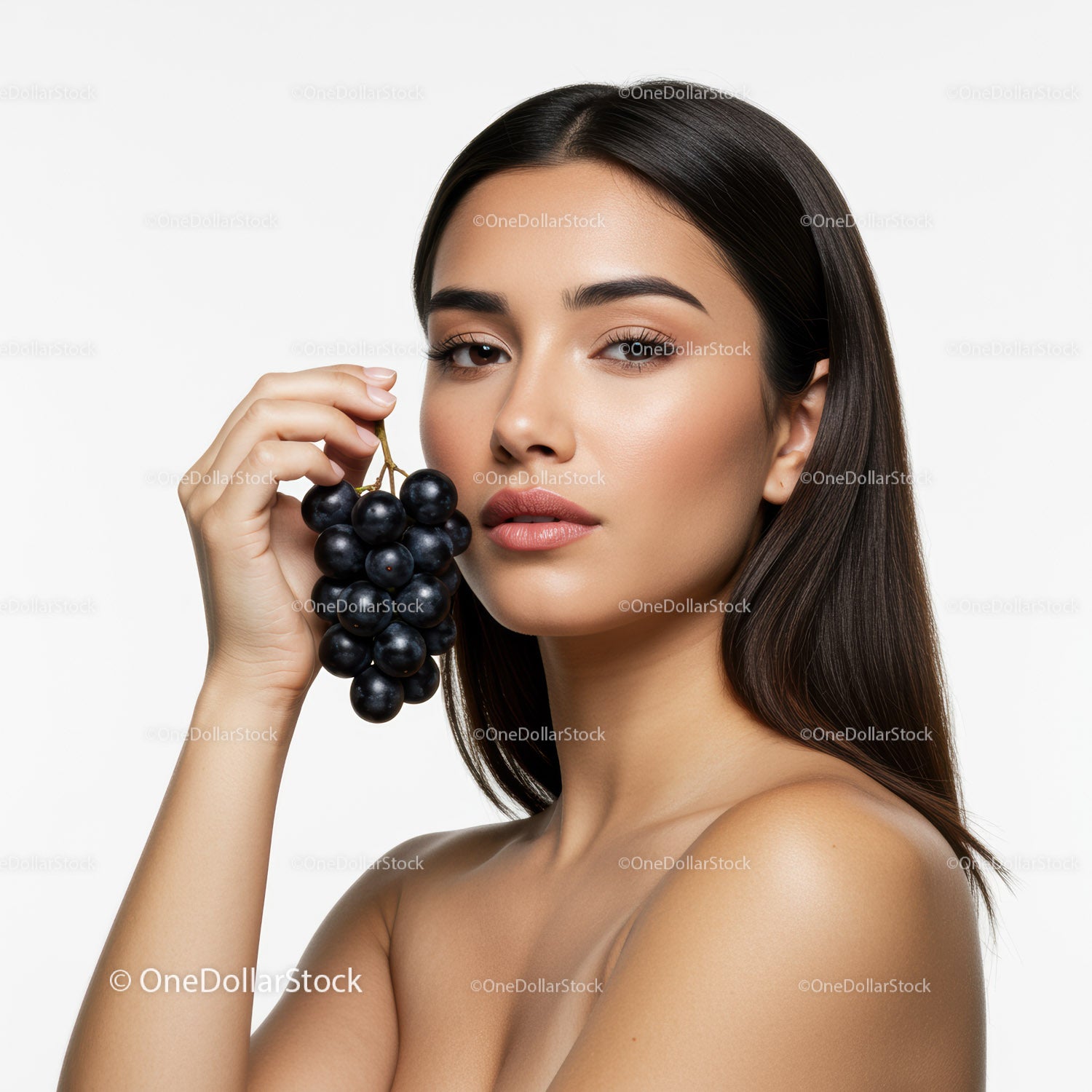 Elegant Woman with Black Grapes in a Minimalist Studio Portrait