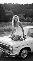 Young woman in white dress with roller skates on car hood