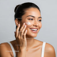 Young Woman Applying Facial Cream with Bright, Clear Skin