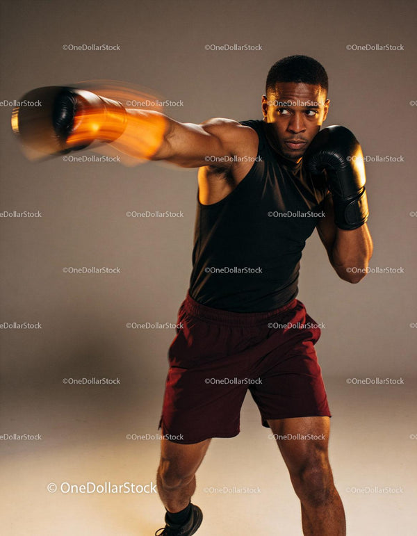 Focused boxer punching with speed and power in studio