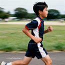 Young boy running confidently on outdoor track