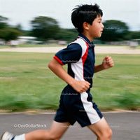Young boy running confidently on outdoor track