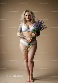 Tattooed Woman in Lingerie Holding Lavender Bouquet in Studio