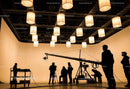 Film Crew Working on Set with Suspended Lantern Lights