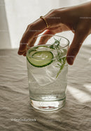 Hand Reaching for Refreshing Cucumber and Herb Sparkling Water