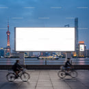 Evening cityscape with cyclists and blank billboard