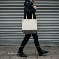 Man walking with canvas tote bag on city street