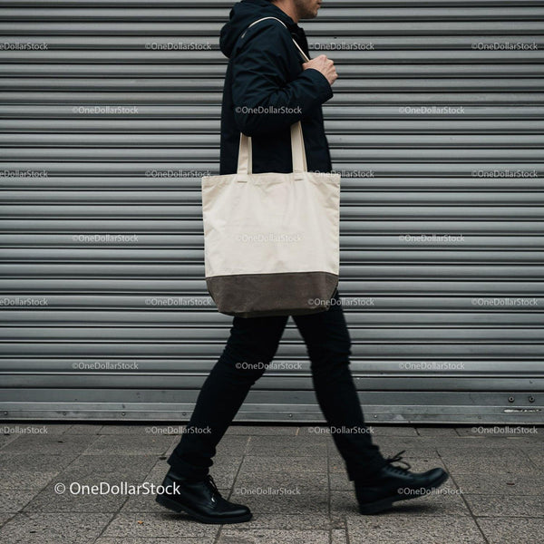 Man walking with canvas tote bag on city street JPG Mockup Image