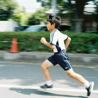 Young boy running outdoors in casual sportswear