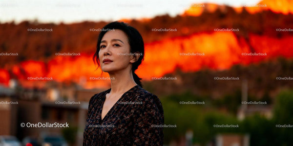 Calm woman standing outdoors at sunset with warm glow