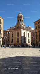 Baroque Church Tower in European City Square with Crowds