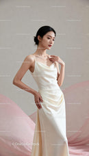 Elegant young woman in silky white gown posing gently