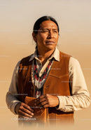 Native American Man Standing in Desert Landscape with Beaded Necklace