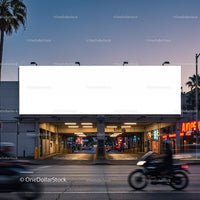 Empty illuminated billboard above city street at dusk