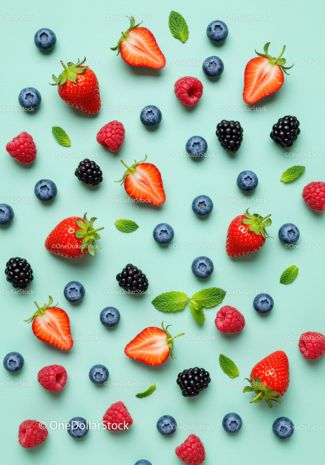 Fresh mixed berries and mint leaves on pastel background