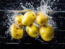 Yellow Passion Fruits Splashing into Water in Vibrant Food Scene