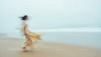 Graceful Woman Walking Along a Serene Beach at Dusk