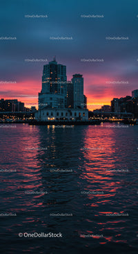 City skyline with vibrant sunset reflecting on water