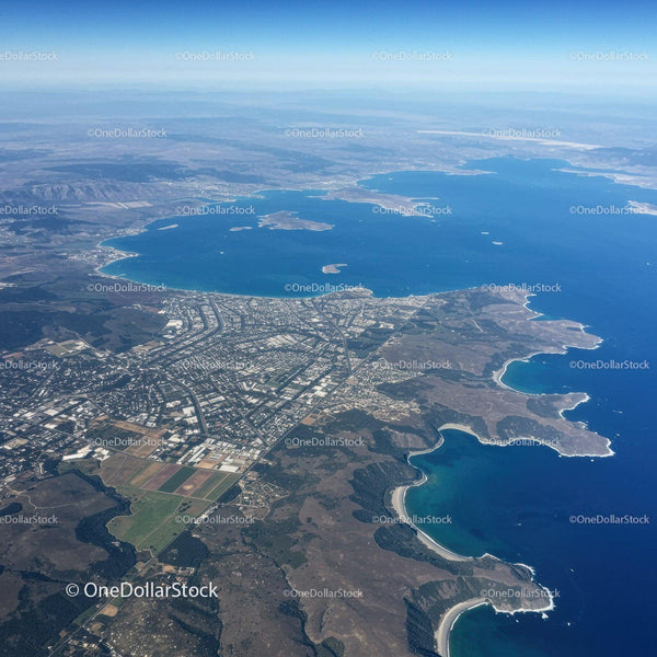 Aerial View of a Large Lake with Mountain Range and Coastal City