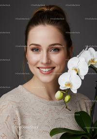 Beautiful Young Woman with White Orchid Flowers and Bright Smile
