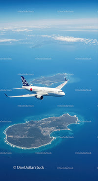 Passenger Jet Flying Over Island with Ocean and Cloudscape